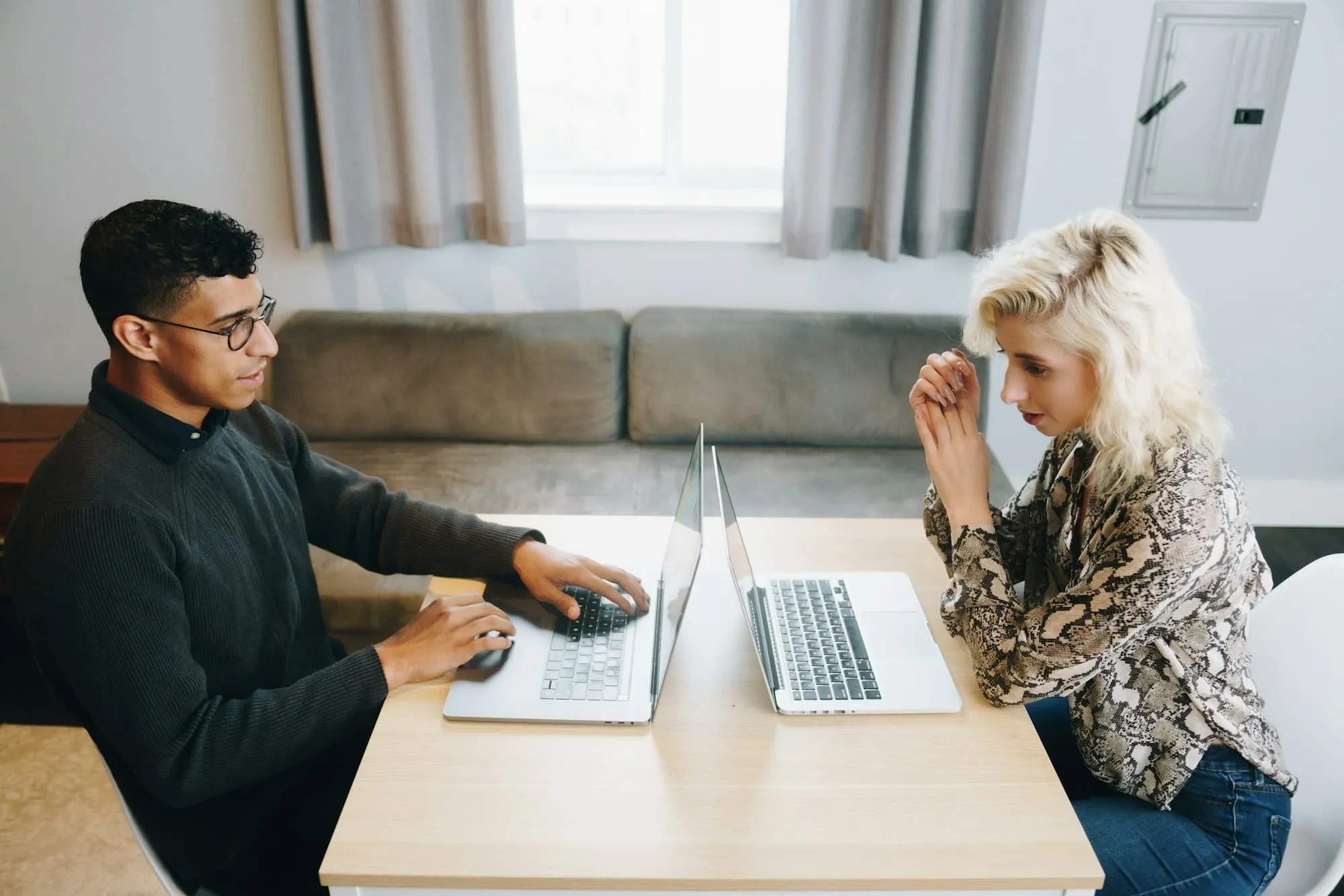 Pareja revisando el borrador de la declaración de la renta en casa con un portátil