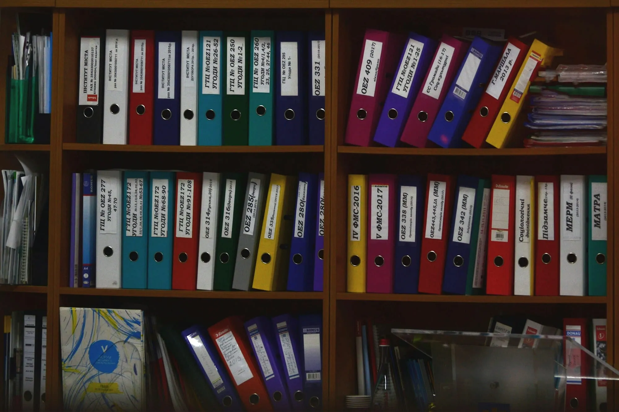 Archivadores de colores ordenados en las estanterías de una oficina